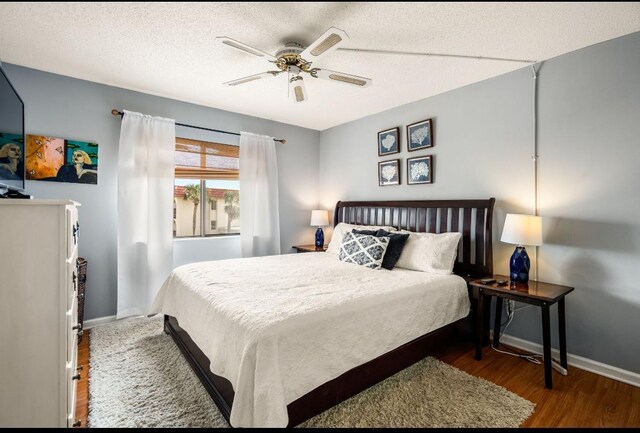 880 A1A Beach Blvd, Saint Augustine Beach, FL 32080 - bedroom featuring baseboards, wood finished floors, a ceiling fan, and a textured ceiling
