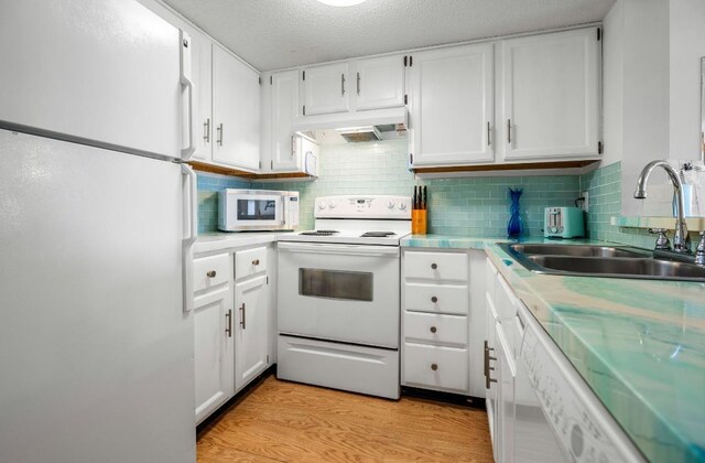 880 A1A Beach Blvd, Saint Augustine Beach, FL 32080 - kitchen with white appliances, range hood, a sink, white cabinetry, and light wood-type flooring