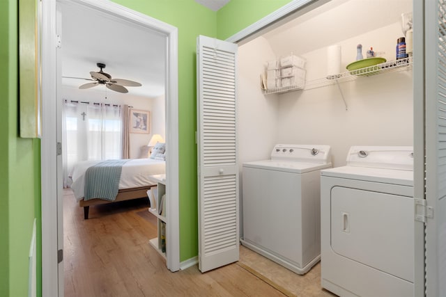 laundry room with ceiling fan, light wood-type flooring, and washing machine and clothes dryer