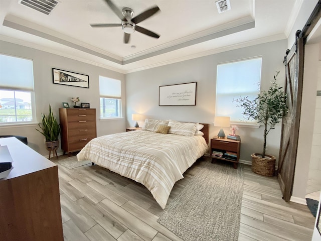 118 Sierras Loop, Saint Augustine, FL 32086 - bedroom with a raised ceiling, a barn door, multiple windows, light wood-style floors, and crown molding