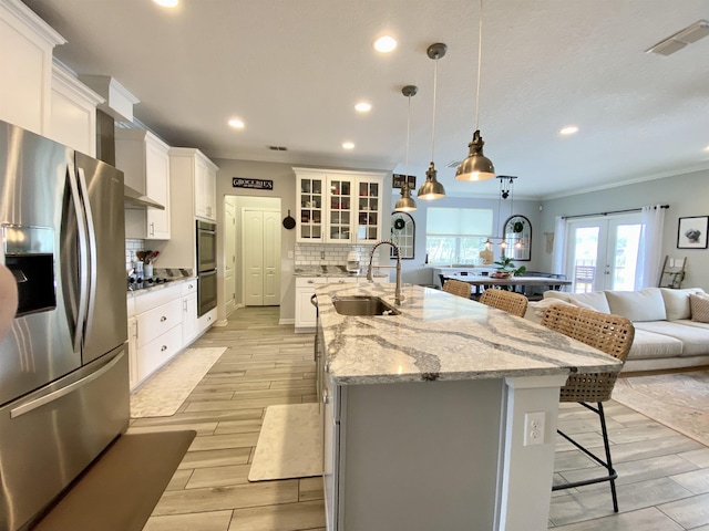118 Sierras Loop, Saint Augustine, FL 32086 - kitchen featuring stainless steel appliances, wall chimney range hood, ornamental molding, a breakfast bar area, and recessed lighting