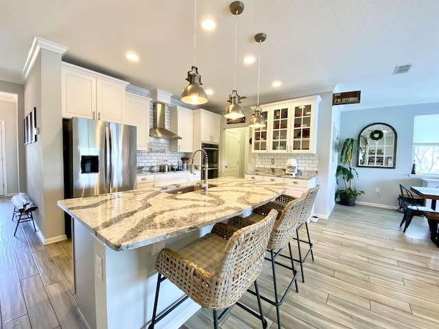 118 Sierras Loop, Saint Augustine, FL 32086 - kitchen with wall chimney exhaust hood, light wood-style flooring, a kitchen bar, backsplash, and recessed lighting