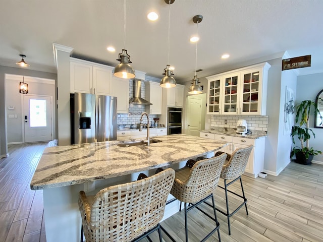 118 Sierras Loop, Saint Augustine, FL 32086 - kitchen with stainless steel appliances, wall chimney exhaust hood, a large island, backsplash, and glass insert cabinets