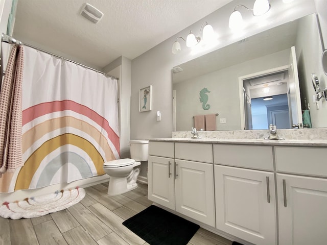 118 Sierras Loop, Saint Augustine, FL 32086 - bathroom featuring double vanity, a textured ceiling, wood finished floors, and a shower with shower curtain