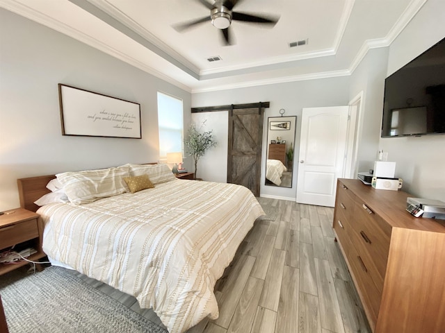 118 Sierras Loop, Saint Augustine, FL 32086 - bedroom with a tray ceiling, a barn door, light wood finished floors, crown molding, and ceiling fan