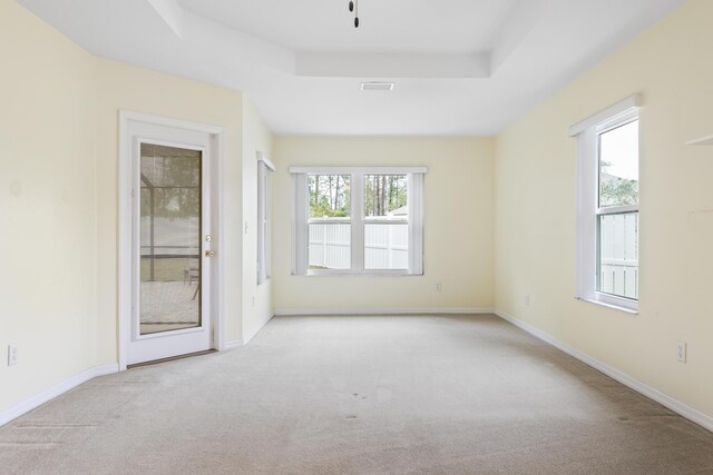 4 Eastgate Ln, Palm Coast, FL 32164 - spare room featuring carpet floors, a tray ceiling, and baseboards