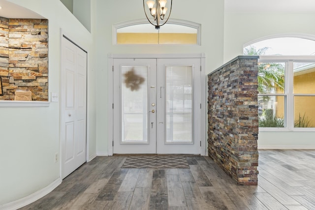 4 Eastgate Ln, Palm Coast, FL 32164 - entrance foyer with french doors, wood finished floors, baseboards, and a chandelier