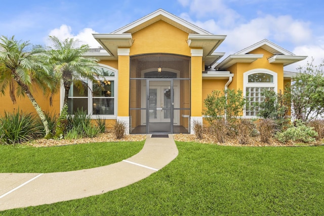 4 Eastgate Ln, Palm Coast, FL 32164 - entrance to property featuring french doors, stucco siding, and a yard