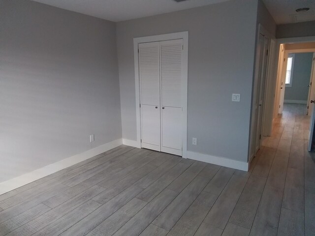 unfurnished bedroom featuring a closet and light wood-type flooring