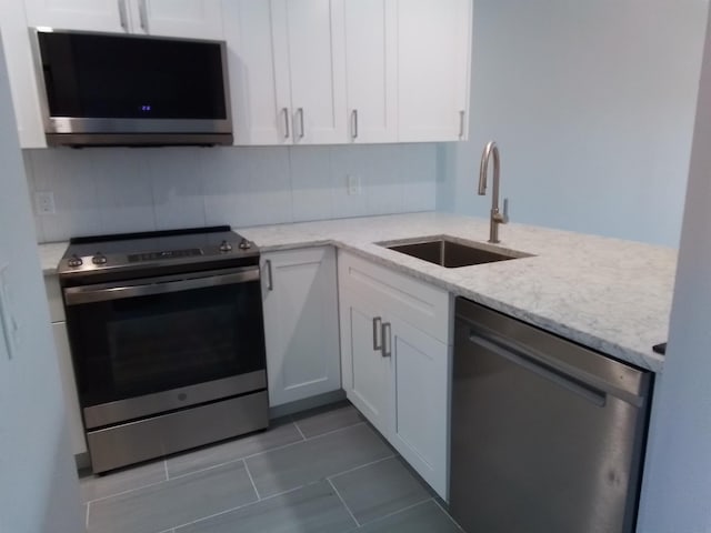 kitchen with sink, white cabinetry, and stainless steel appliances