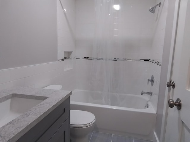 full bathroom featuring vanity, toilet, tile walls, and tiled shower / bath