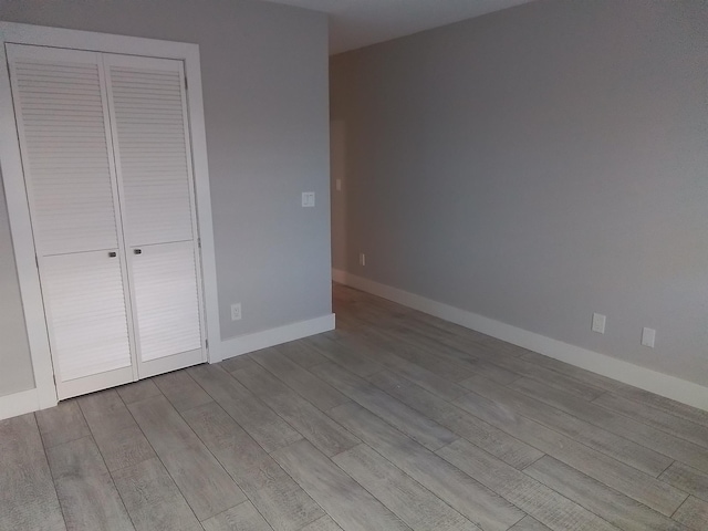 unfurnished bedroom featuring a closet and light hardwood / wood-style flooring