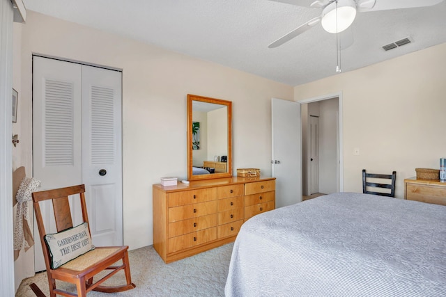 bedroom with light carpet, ceiling fan, and a closet