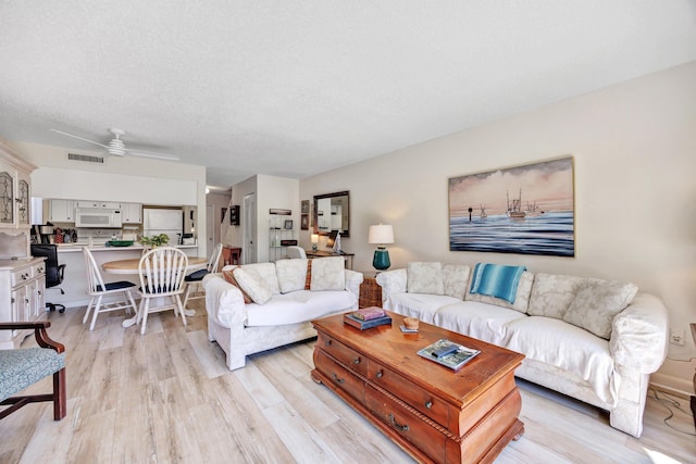 living room featuring light hardwood / wood-style flooring and a textured ceiling