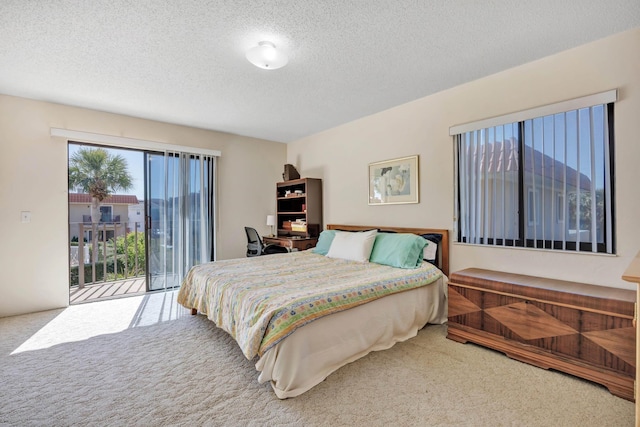 bedroom featuring access to outside, a textured ceiling, and carpet