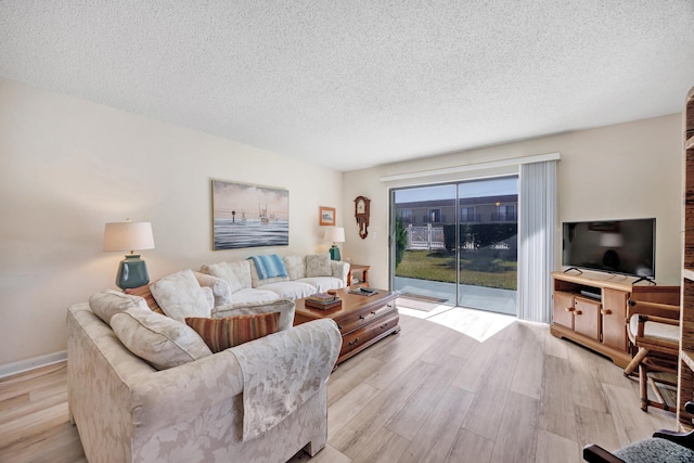 living room featuring a textured ceiling and light wood-type flooring