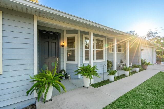 entrance to property with covered porch and an attached garage