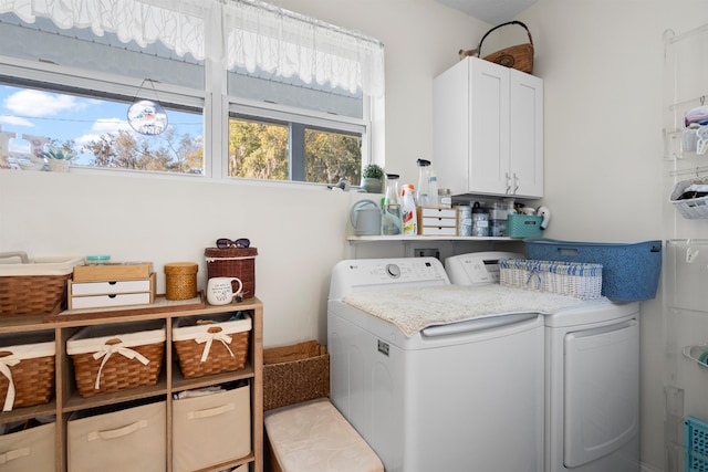 washroom with cabinet space and washer and dryer