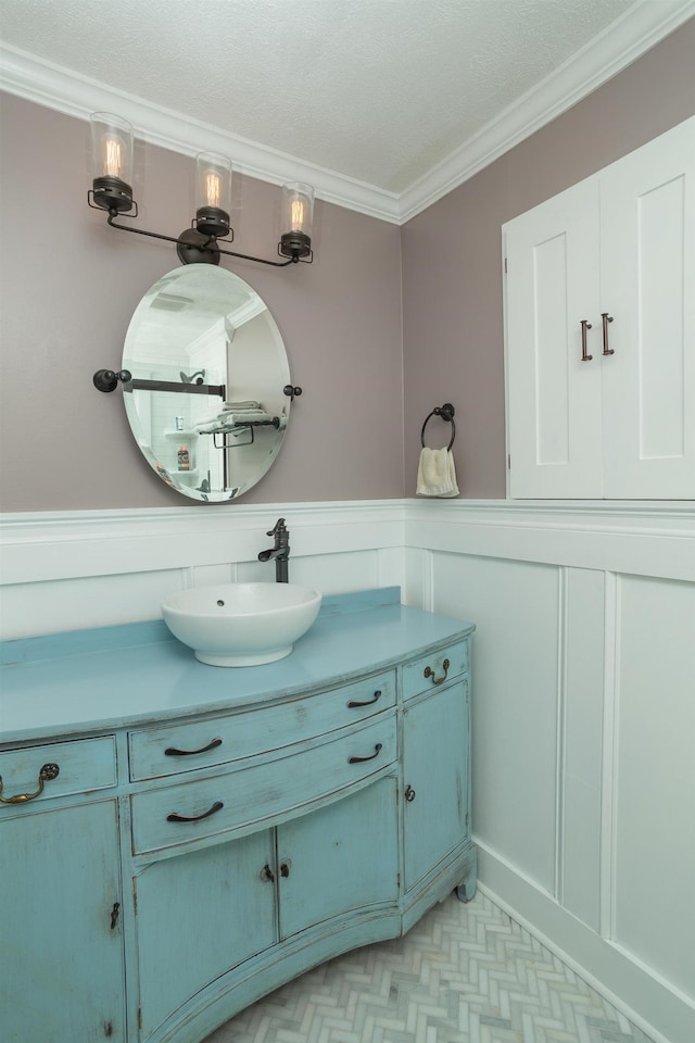 6 E Park Ave, Saint Augustine, FL 32084 - bathroom featuring vanity, ornamental molding, a decorative wall, and wainscoting