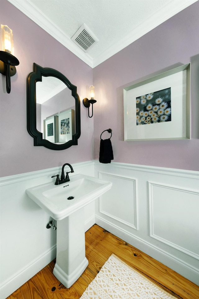 6 E Park Ave, Saint Augustine, FL 32084 - bathroom featuring ornamental molding, wood finished floors, a wainscoted wall, and a decorative wall