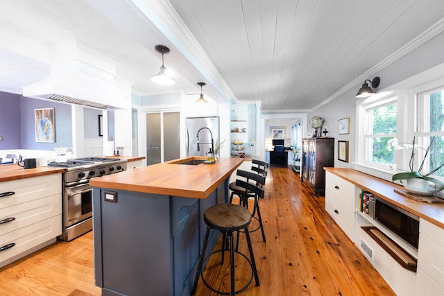 6 E Park Ave, Saint Augustine, FL 32084 - kitchen featuring butcher block countertops, gas range, ornamental molding, white cabinets, and light wood-style flooring