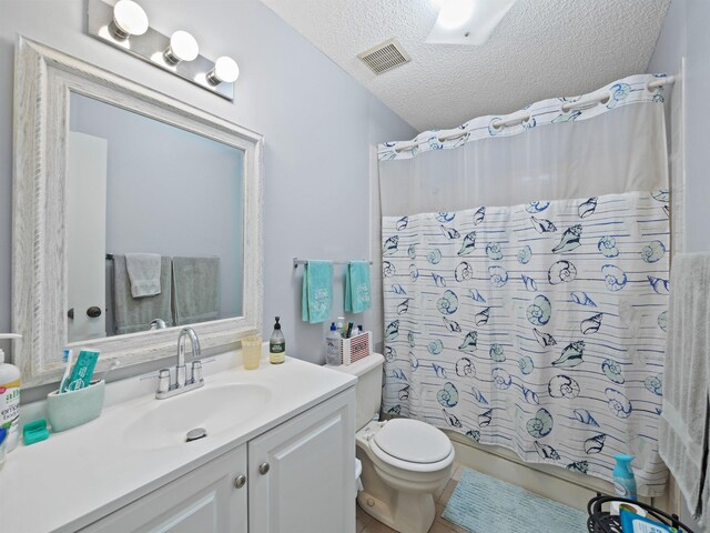 bathroom with a shower with curtain, vanity, a textured ceiling, and toilet