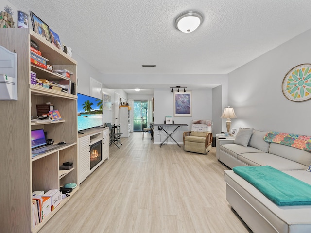 living room featuring light hardwood / wood-style floors and a textured ceiling