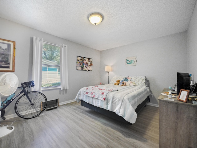 bedroom with wood-type flooring and a textured ceiling