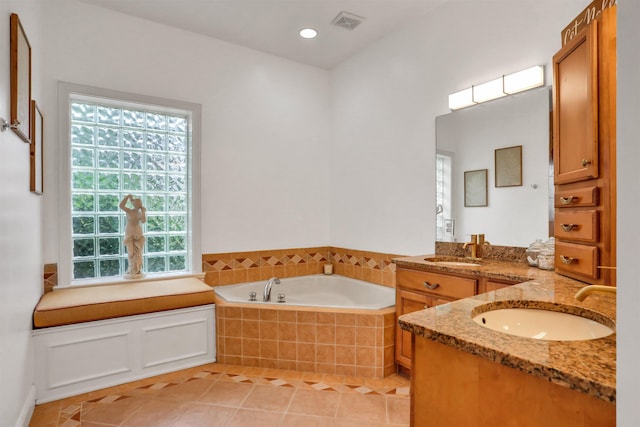 bathroom with vanity, a relaxing tiled tub, tile patterned floors, and a wealth of natural light