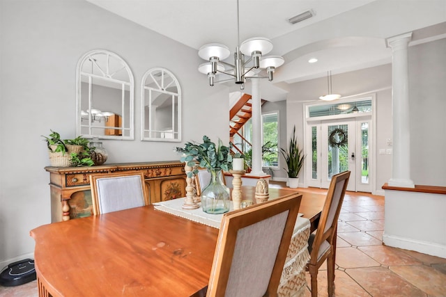 dining space with an inviting chandelier, light tile patterned floors, and decorative columns