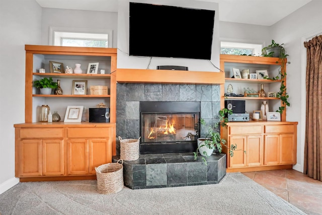 living room with a tile fireplace and a wealth of natural light