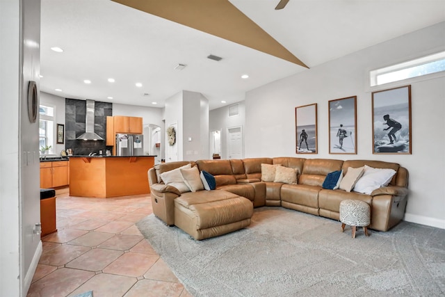 tiled living room with plenty of natural light and lofted ceiling