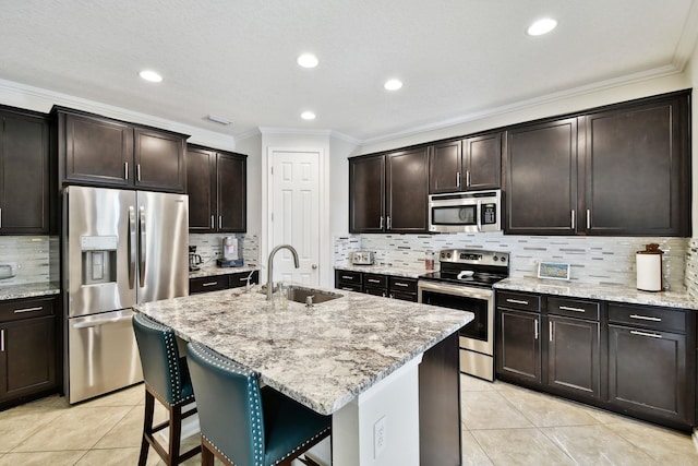 kitchen featuring sink, dark brown cabinetry, stainless steel appliances, and an island with sink