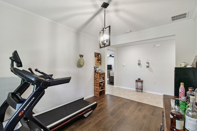 workout room featuring hardwood / wood-style flooring and ornamental molding