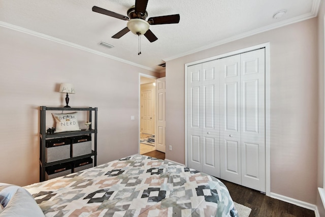 bedroom with dark hardwood / wood-style flooring, a textured ceiling, ceiling fan, crown molding, and a closet