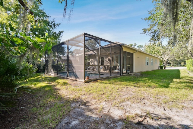 back of property with a lawn and glass enclosure