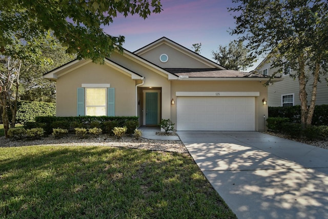 view of front of home with a garage and a lawn