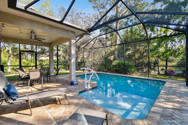 view of pool with ceiling fan, a patio, and glass enclosure