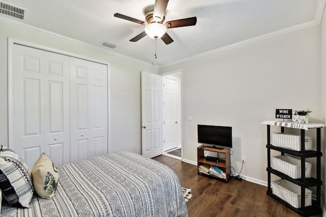 bedroom featuring ceiling fan, crown molding, dark wood-type flooring, and a closet