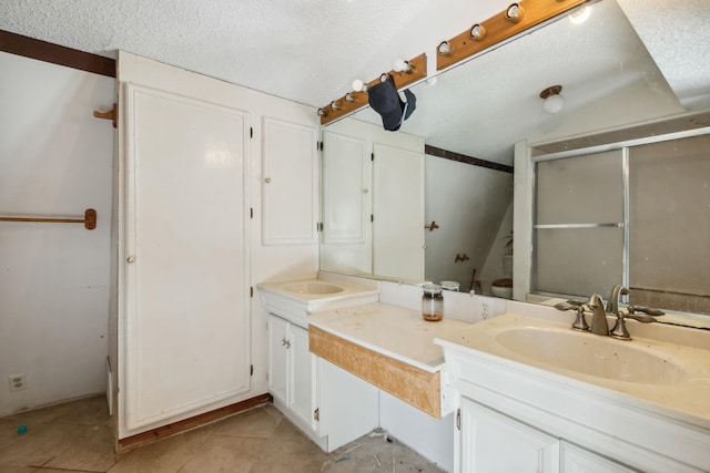 bathroom with vanity, a textured ceiling, and tile patterned floors