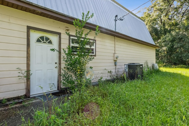 exterior space featuring cooling unit and a lawn