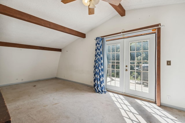 carpeted empty room featuring vaulted ceiling with beams, ceiling fan, french doors, and a textured ceiling