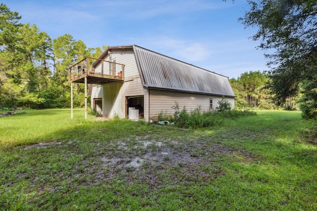 view of side of home featuring a yard and a wooden deck