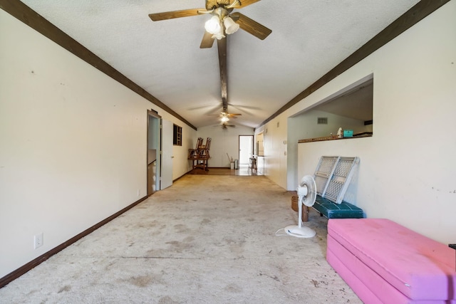 interior space with vaulted ceiling with beams, ceiling fan, and a textured ceiling