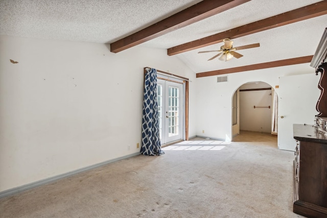 unfurnished living room with vaulted ceiling with beams, ceiling fan, light carpet, and a textured ceiling