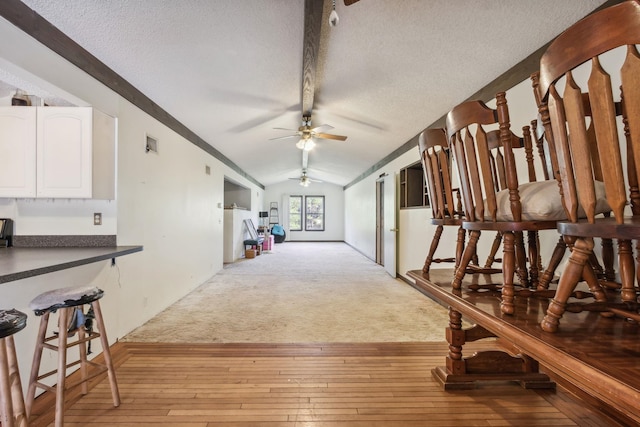 interior space with light colored carpet, a textured ceiling, and vaulted ceiling