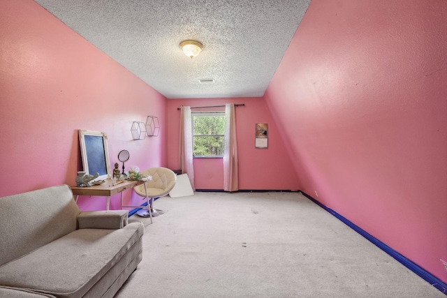 living area featuring carpet flooring, lofted ceiling, and a textured ceiling