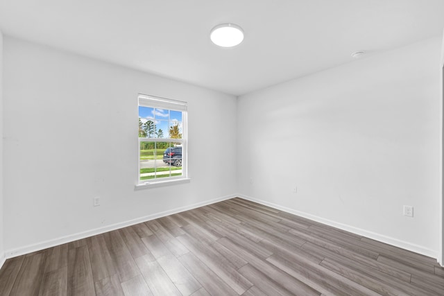 unfurnished room with wood-type flooring