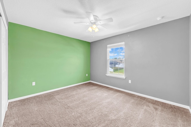 carpeted empty room featuring a textured ceiling and ceiling fan