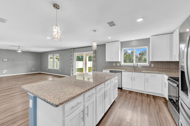 kitchen with white cabinets, sink, a wealth of natural light, and stainless steel appliances